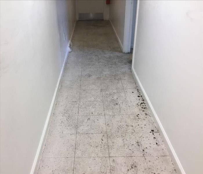 Hallway with tile floor with dirt and debris